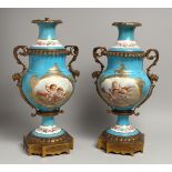 A PAIR OF 19TH CENTURY FRENCH SEVRES PORCELAIN TWO HANDLED LAMPS with ormolu masks, painted with