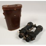 A PAIR OF MILITARY BINOCULARS in a leather case.