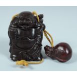 A JAPANESE CARVED WOOD BUDDHA INRO on a string. 8.5cm long.