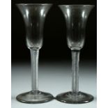 A PAIR OF GEORGIAN WINE GLASSES with inverted shaped bell bowls and air twist stems. 7.25ins high.