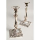 A PAIR OF GEORGE III SILVER CANDLESTICKS with acanthus leaves, bead edge and square bases. London