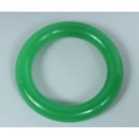 AN APPLE JADE CARVED BANGLE.