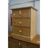 A pine three drawer bedside chest.