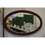 A mahogany oval mirror.