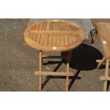 A folding circular shaped hardwood coffee table.