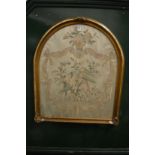 A 19th century arch shaped silk work picture, framed and glazed.