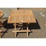 A folding square shaped hardwood coffee table.