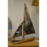 An aluminium model of a sailing boat.