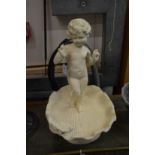 A small cast iron bird bath modelled as a cherub standing in a shell.