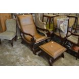 A mahogany and leather cloth upholstered armchair with matching foot stool.