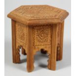 A SMALL CARVED WOODEN MODEL OF AN ISLAMIC TABLE, 9cm high.