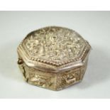 AN ISLAMIC WHITE METAL OCTAGONAL QUR'AN AMULET BOX, possibly silver, 5.5cm diameter.