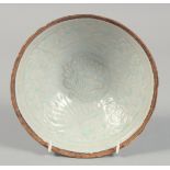 A CHINESE CELADON GLAZE BOWL, with carved floral decoration to the interior, 18cm diameter.