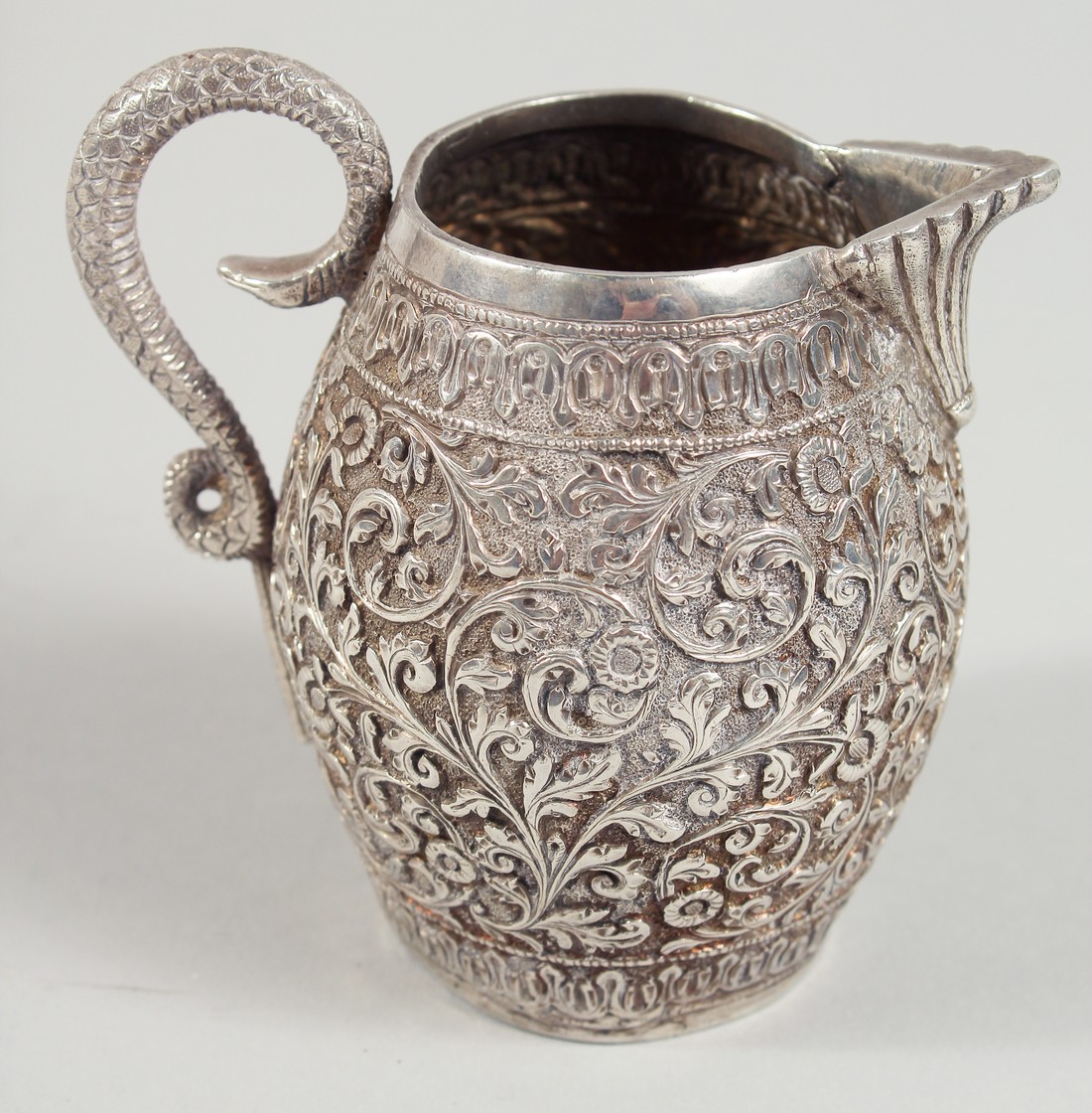 AN INDIAN WHITE METAL ENGRAVED AND CHASED CREAM JUG, with scrolling foliate decoration. 9.5cm high. - Image 3 of 6