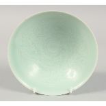 A CHINESE CELADON GLAZE BOWL, with incised decoration to the interior, 20.5cm diameter.