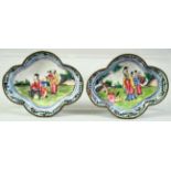 A SMALL PAIR OF CHINESE QUATREFOIL FORM ENAMEL DISHES, painted with figures in a garden, 9cm x 7.
