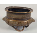 A SMALL CHINESE BRONZE CENSER, with lion dog handles and raised on three bamboo branch formed