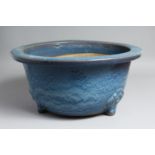 A LARGE CHINESE BLUE-GLAZED PLANTER, slightly raised on three moulded feet. 39.5cm diameter