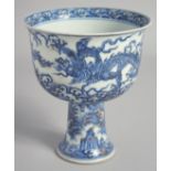 A CHINESE BLUE AND WHITE PORCELAIN PEDESTAL BOWL, painted with dragons above stylised waves, 17cm