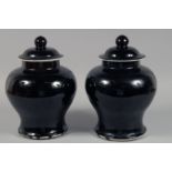 A PAIR OF CHINESE DARK BROWN GLAZE JARS AND COVERS. 30cm high overall