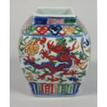 A CHINESE WUCAI PORCELAIN SQUARE FORM JAR, painted with dragons and with six-character mark to base,