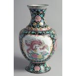 A LARGE CHINESE BLACK GROUND ENAMELLED VASE, painted with two panels; one depicting an exotic