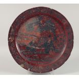 A LARGE 17th CENTURY RED LACQUERED CHARGER depicting a male figure and a seated female musician.