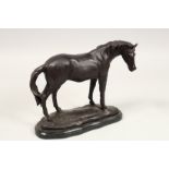 A BRONZE HORSE on a shaped marble base. 10ins long