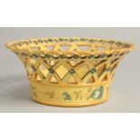 A CONTINENTAL YELLOW GROUP PIERCED CIRCULAR BASKET painted with flowers. 8ins diameter.