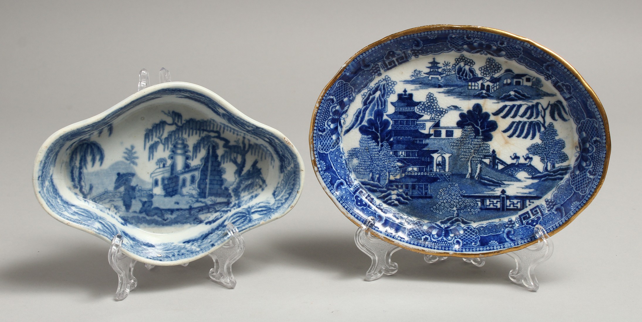 TWO BLUE AND WHITE WILLOW PATTERN DISHES.