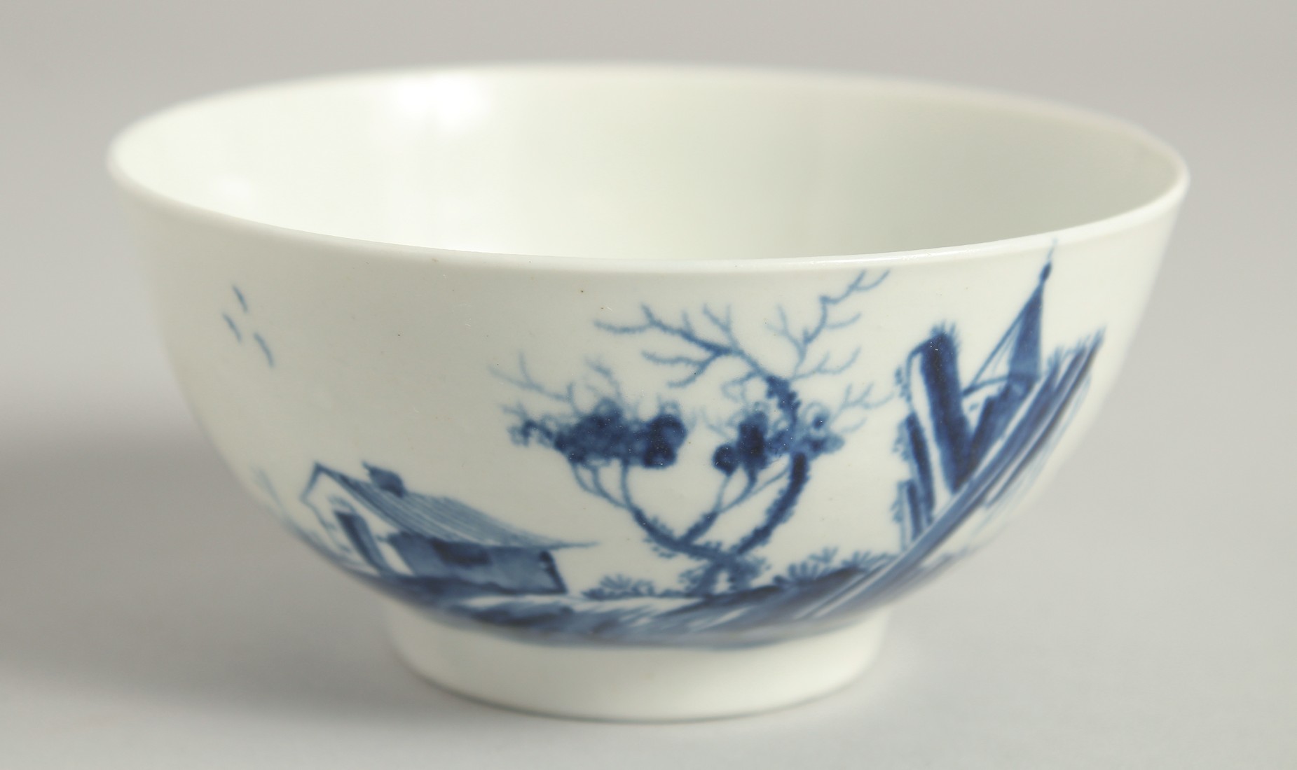 AN EARLY 18TH CENTURY WORCESTER BOWL finely painted in underglaze blue with the Gazebo pattern.