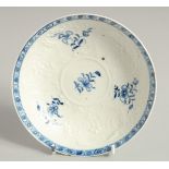 AN EARLY 18TH CENTURY, RARE LOWESTOFT SAUCER, moulded with flowers and cartouches, each painted with