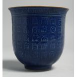 A CHINESE BLUE GLAZE PORCELAIN CUP, the exterior with calligraphy, base with six-character mark. 9cm