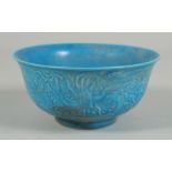 A SMALL CHINESE BLUE PORCELAIN CIRCULAR BOWL with dragons in relief. 6ins diameter.