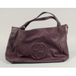 A LARGE GUCCI MAROON LEATHER SOFT BAG, 'G' on the side. 18ins x 12 ins with two leather handles.