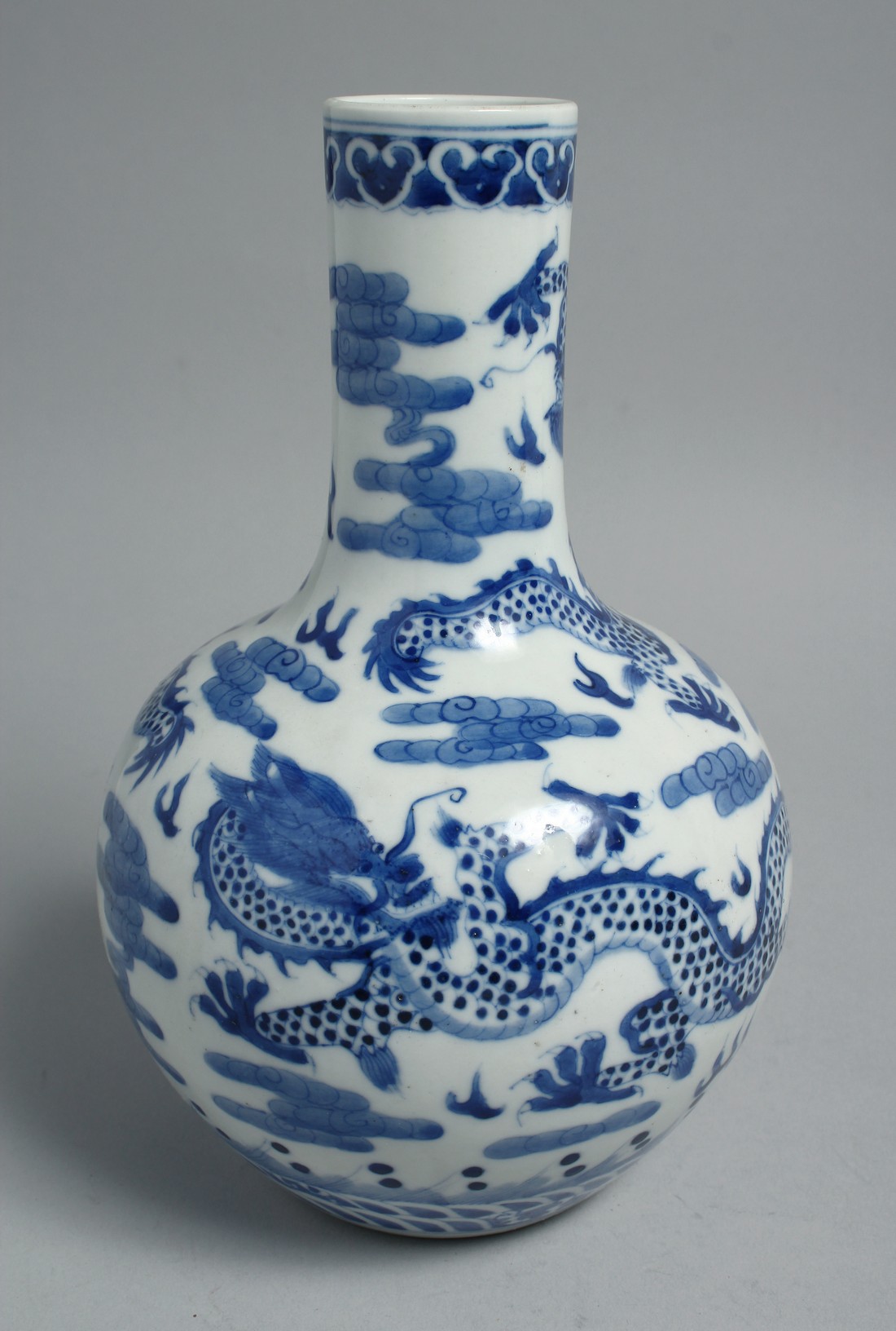 A CHINESE BLUE AND WHITE PORCELAIN BOTTLE VASE, painted with dragons and the flaming pearl of