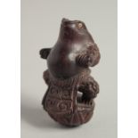 A CARVED WOOD FROG NETSUKE.