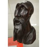 A carved wood bust of a bearded man.