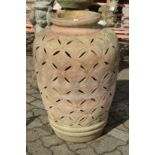 A large terracotta urn with pierced decoration.