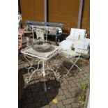 A wrought iron folding patio table and pair of matching chairs.