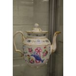 A porcelain teapot decorated with a ewer and ribbon amongst floral sprays.