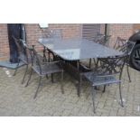 A good marble and cast metal patio dining table with six armchairs and cushions.