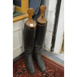 A pair of black leather hunting boots with wooden trees.