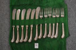 A set of six silver pistol handled knives and forks.