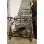 An ornate wrought iron cooking pot stand complete with cooking pot.