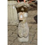 A composite garden ornament modelled as a kneeling female figure.