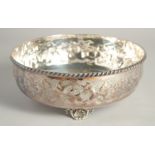 A CONTINENTAL SILVER PLATED BOWL with floral repousse decoration supported on three shell feet. 9.