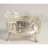 A CONTINTENTAL .800 SILVER AND GLASS CIRCULAR FRUIT BOWL of Adam design supported on four claw feet.