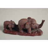 A JAPANESE CARVED WOOD ELEPHANT AND YOUNG. Signed, 4.5ins long.