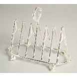 A SILVER PLATED SIX DIVISION TOAST RACK, riding crops and foxes' heads.